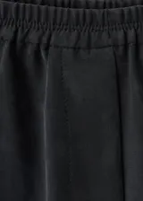 Pantalón largo estilo balloon de tiro medio, confeccionado en mezcla de lyocell y poliéster, con cintura elástica, bolsillos laterales y bajo con goma elástica.