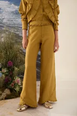 Pantalón wide leg de color mostaza con detalle de volados en la cintura y en el ruedo.