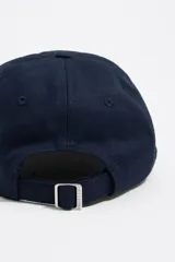 Gorra de béisbol azul marino con bordado floral multicolor en el frente y logo de la marca.