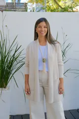 Saco abierto tipo cárdigan color crudo, de corte recto y largo medio, con mangas largas y dos bolsillos frontales aplicados.