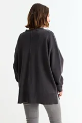 Cardigan de punto color fucsia, con cuello en V, cierre frontal con botones y bolsillos laterales. Presenta un diseño holgado con mangas largas y puños acanalados.