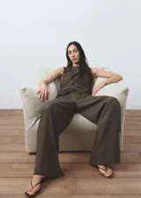 Pantalón de corte recto y pernera ancha, color verde militar con sutiles rayas verticales. Cuenta con cintura elástica con cordón ajustable y bolsillos laterales.