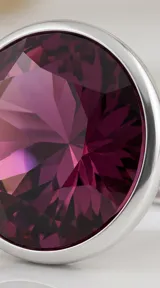 Anillo de plata con cristal redondo facetado en color amatista, engarzado en un diseño minimalista.