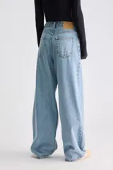 Jean balloon de tiro alto, confeccionado en denim rígido color celeste, con costuras verticales expuestas en el frente y perneras amplias.