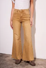 Pantalón de jean estilo wide leg con tiro alto, color camel con efecto lavado. Presenta diseño de cinco bolsillos, cierre frontal con botón y cremallera, y ruedo desflecado.