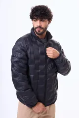 Campera puffer negra con diseño termosellado, cuello alto y cierre frontal completo. Confeccionada en nylon, ofrece ligereza y protección.