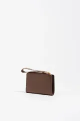 Billetera pequeña de estructura rígida, color negro, con estampado frontal en color dorado con la palabra "BIMBA". Posee cierre superior con tirador de tela amarillo mostaza.