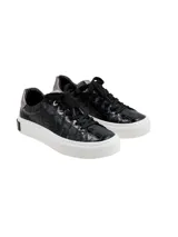 Championes negros de cuero con textura simil cocodrilo, cordones negros y suela blanca de plataforma plana.