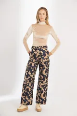 Pantalón de brocato con estampado de hojas de ginkgo en tonos azulados y beige, tiro medio y piernas rectas.