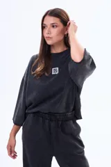 Buzo de felpa con cuello redondo a la base, de corte holgado y mangas tres cuartos con terminación desflecada. Presenta un acabado efecto lavado en color marrón.