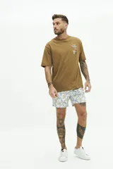 Short de baño con estampado floral en tonos beige, gris y blanco. Cuenta con cintura elástica con cordón de ajuste, dos bolsillos laterales y uno trasero.