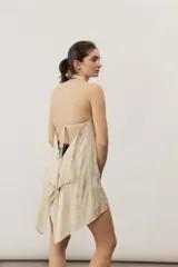 Top halter celeste con diseño asimétrico de corte más largo en la parte trasera, cuello alto y sutil estampado floral.