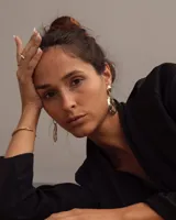 Par de aros colgantes de bronce y alpaca color plateado, con forma orgánica irregular y textura martillada. Cierre con perno y mariposa de plata 925.