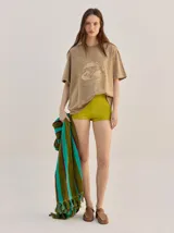 Remera oversize de corte cuadrado, color verde, con cuello redondo y estampa retro centrada en tono amarillo.