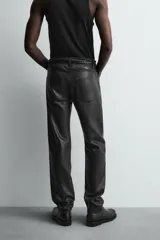 Pantalón slim fit confeccionado en piel, con diseño de cinco bolsillos, cierre frontal de cremallera y botón.