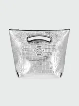 Bolso de hombro mediano con acabado metalizado plateado y textura de efecto cocodrilo. Presenta un diseño estructurado con asa superior integrada y el logo metálico de la marca en el frente.