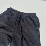 Pantalón negro de tiro alto y corte palazzo con cordón ajustable en la cintura.