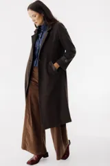 Tapado largo color marrón con solapas, cierre con botones y bolsillos laterales.