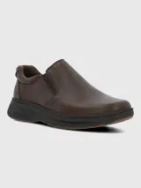 Zapato tipo slip-on de cuero marrón con paneles elásticos laterales para un ajuste cómodo y suela de goma oscura con diseño estriado.