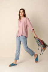 Camisa de lino color rosado, de corte holgado y cuello mao, con mangas 3/4 y cierre frontal con botones. 
