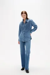 Camisa de jean negro con diseño de frunces verticales en el frente, cuello clásico, cierre frontal con botones y mangas largas con puños abotonados.