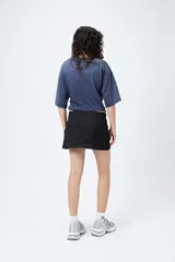 Minifalda color beige estilo cargo, de tiro bajo y corte recto, con bolsillos laterales.