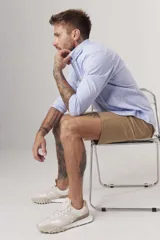 Camisa de hombre color crema, de corte clásico, con cuello abotonado y mangas largas.