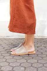 Sandalias bajas color beige con base marrón, de cuero y hechas a mano en Uruguay.