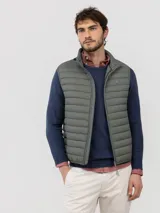 Chaleco acolchado para hombre de nylon reciclado, color verde militar, con cierre de cremallera frontal, bolsillos laterales y cuello alto.
