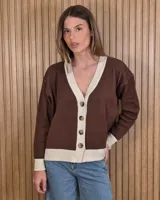 Cardigan de punto color marrón con detalles en tono arena en los bordes de la botonera, cuello en V, dobladillo y puños. Cuenta con cierre frontal de botones.