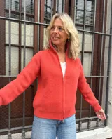 Campera de punto color rojo bermellón, con cuello alto y cierre frontal completo. Presenta mangas largas con puños acanalados y diseño de tejido texturizado.