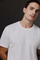 Pack de dos remeras de algodón, una blanca y una negra, con cuello redondo y etiqueta de la marca Carouomo en el interior.