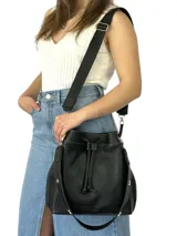 Bolso tipo marinero de cuero negro con correa corta de cuero para usar al hombro y correa larga de tela con logo para usar cruzado.