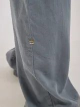 Pantalón de tiro medio alto, color beige, con bolsillos delanteros y traseros. Presenta detalles de atraques y triples costuras en color amarillo. Confeccionado en una mezcla de lino, algodón y viscosa.