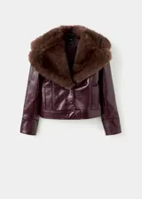 Chaqueta corta efecto piel color bordó, con cuello de solapa y detalle de pelo sintético en el cuello, cierre frontal de botones, bolsillos laterales y forro interior.