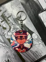 Llavero circular con ilustración de Hanako kun, personaje del anime Toilet bound Hanako kun. Incluye aro metálico y cadena.