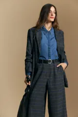 Pantalón de tiro alto con diseño a cuadros, corte wide leg y silueta amplia de caída fluida.