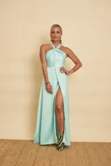 Vestido largo de satén color celeste menta, con escote halter cruzado y falda fluida con abertura frontal.