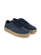 Championes de gamuza azul marino, con cordones al tono y suela texturizada de goma en color tostado.