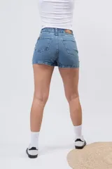 Short pollera de denim en lavado azul medio clásico, con diseño de mini falda en el frente y short incorporado.