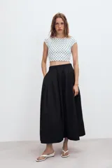 Falda midi de tiro alto en color verde militar, con diseño acampanado y cintura elástica. Presenta costuras verticales que definen su estructura y cierre lateral con cremallera oculta.