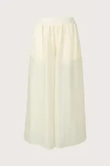 Pantalón fluido color crema, de corte ancho y relajado, con cintura elástica fruncida.