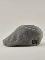 Boina de estilo clásico confeccionada en tejido de lana gris melange, con etiqueta decorativa de la marca Benson & Thomas en el lateral.