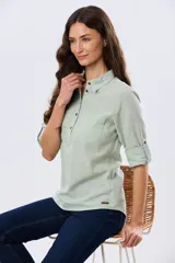 Camisa de lino lisa color celeste, de manga larga con puños abotonados y trabilla para arremangar. Cuenta con cuello clásico, cierre frontal con botones y bolsillos plaqué en el pecho.