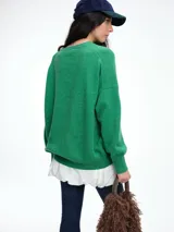 Sweater de tejido de punto en color rosa claro con motas de colores, de corte holgado, cuello redondo y mangas largas con hombros caídos.