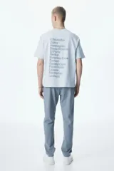 Pantalón de vestir gris claro, de corte slim fit, con bolsillos laterales y traseros. Se ajusta a la cintura con cierre y botón.
