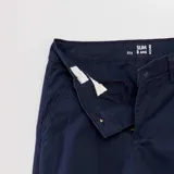 Pantalón chino azul marino, de corte slim, con bolsillos laterales y traseros. Cierre con botón y cremallera.