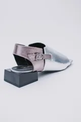 Sandalias de cuero color marrón con puntera abierta, talón descubierto y tira trasera con hebilla. Taco bajo de madera.