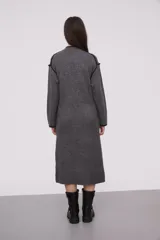 Vestido midi gris de tejido de punto, con cuello redondo y mangas largas. Presenta ribete negro en cuello, puños y hombros.