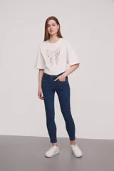 Pantalón jean de corte skinny y tiro medio, con diseño clásico de cinco bolsillos y costuras reforzadas.